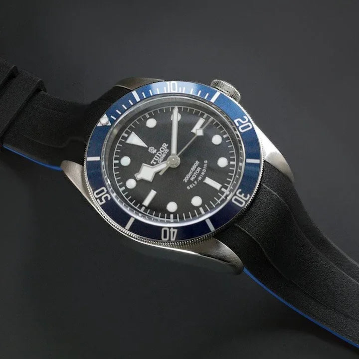 Montre Tudor Black Bay avec lunette bleue et bracelet en caoutchouc noir, accessoire luxe.