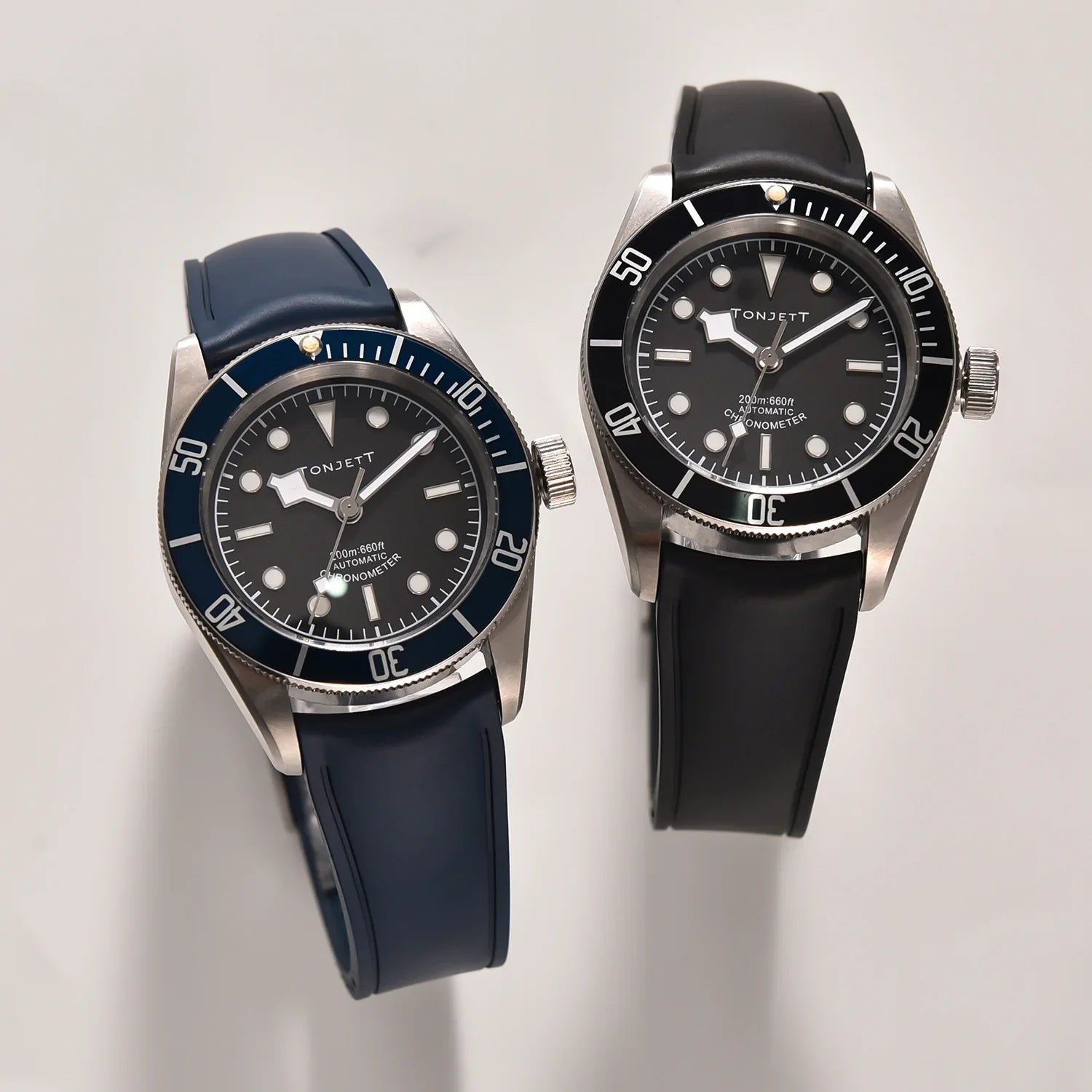 Deux montres automatiques Tonjett avec bracelets en caoutchouc sur fond clair, accessoires de luxe.
