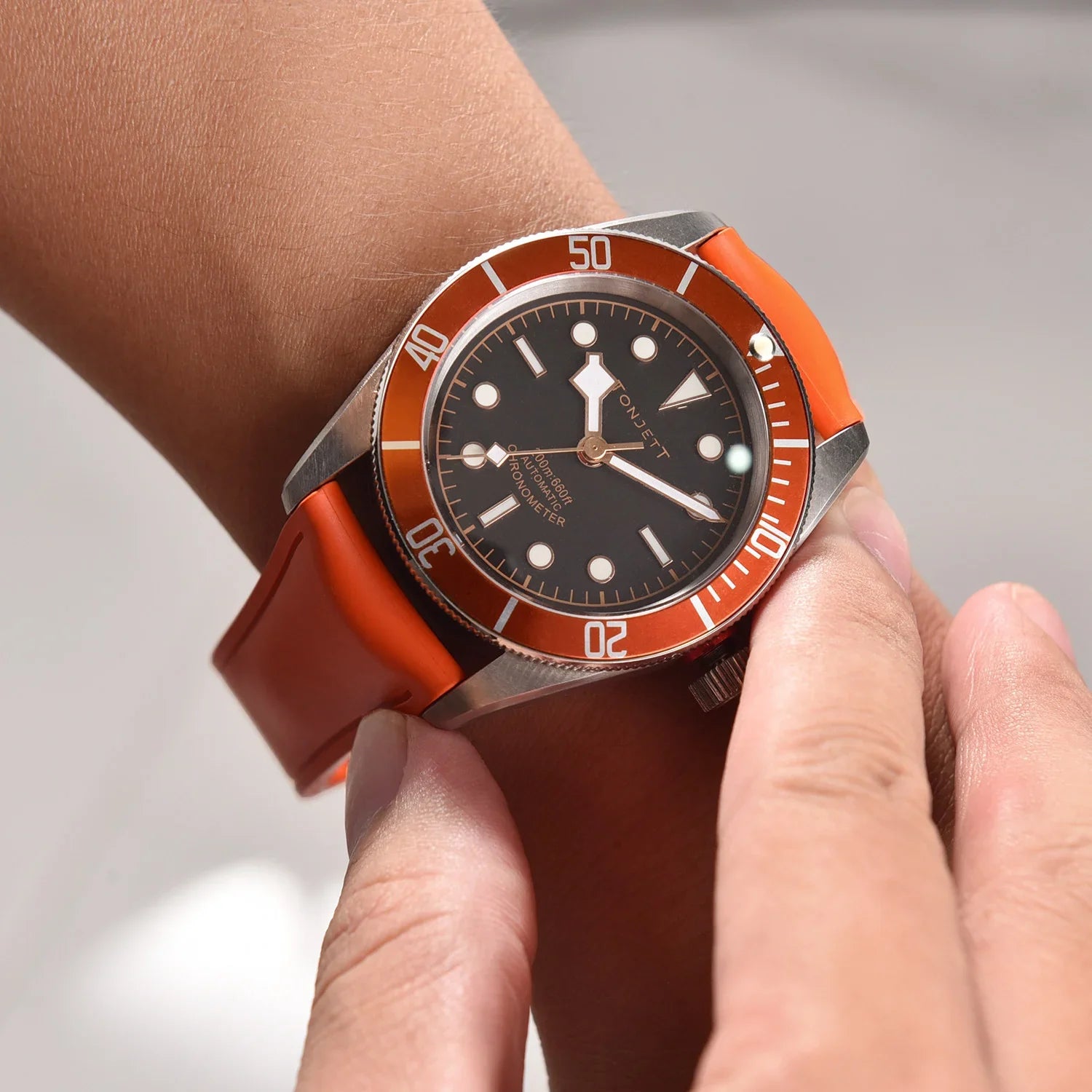 Montre de luxe avec bracelet orange portée au poignet, accessoire misterchrono.com
