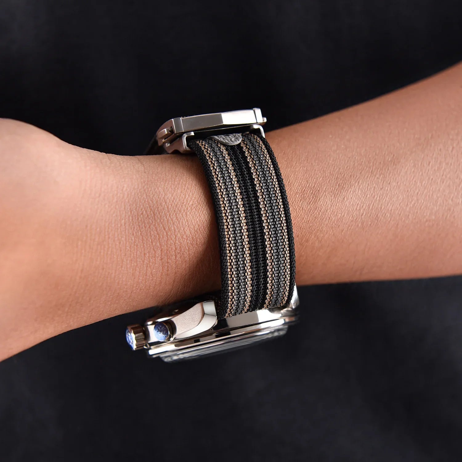 Bracelet de montre NATO noir et beige sur un poignet, accessoire luxe misterchrono.com